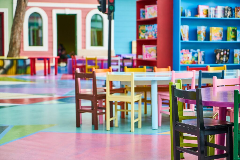 Un aula con varias mesas y sillas de colores