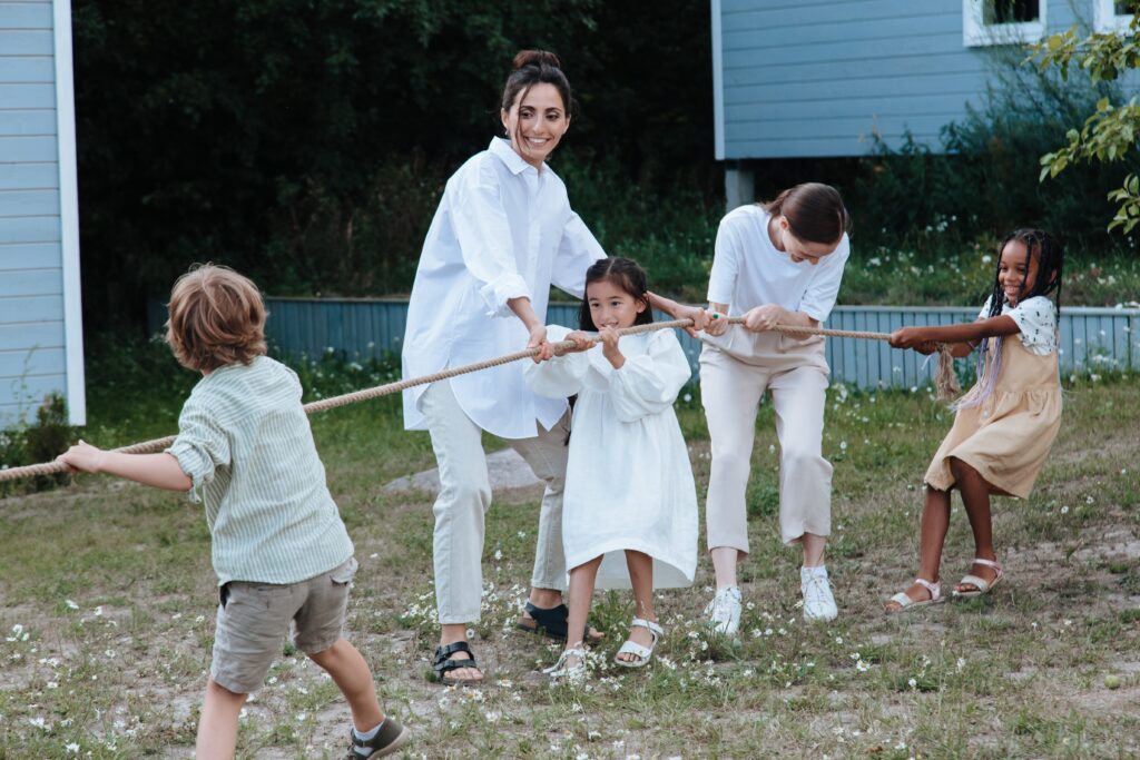 Tres niños y dos mujeres tiran juntos de una cuerda