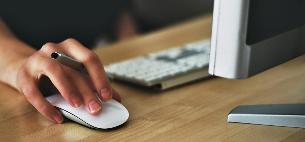 Accesibilidad web. En la imagen se ve una mano de una persona, usando el ratón del ordenador.